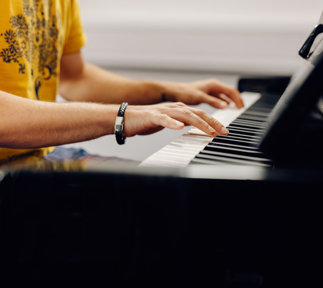 A close up shot of a piano with two hands playing