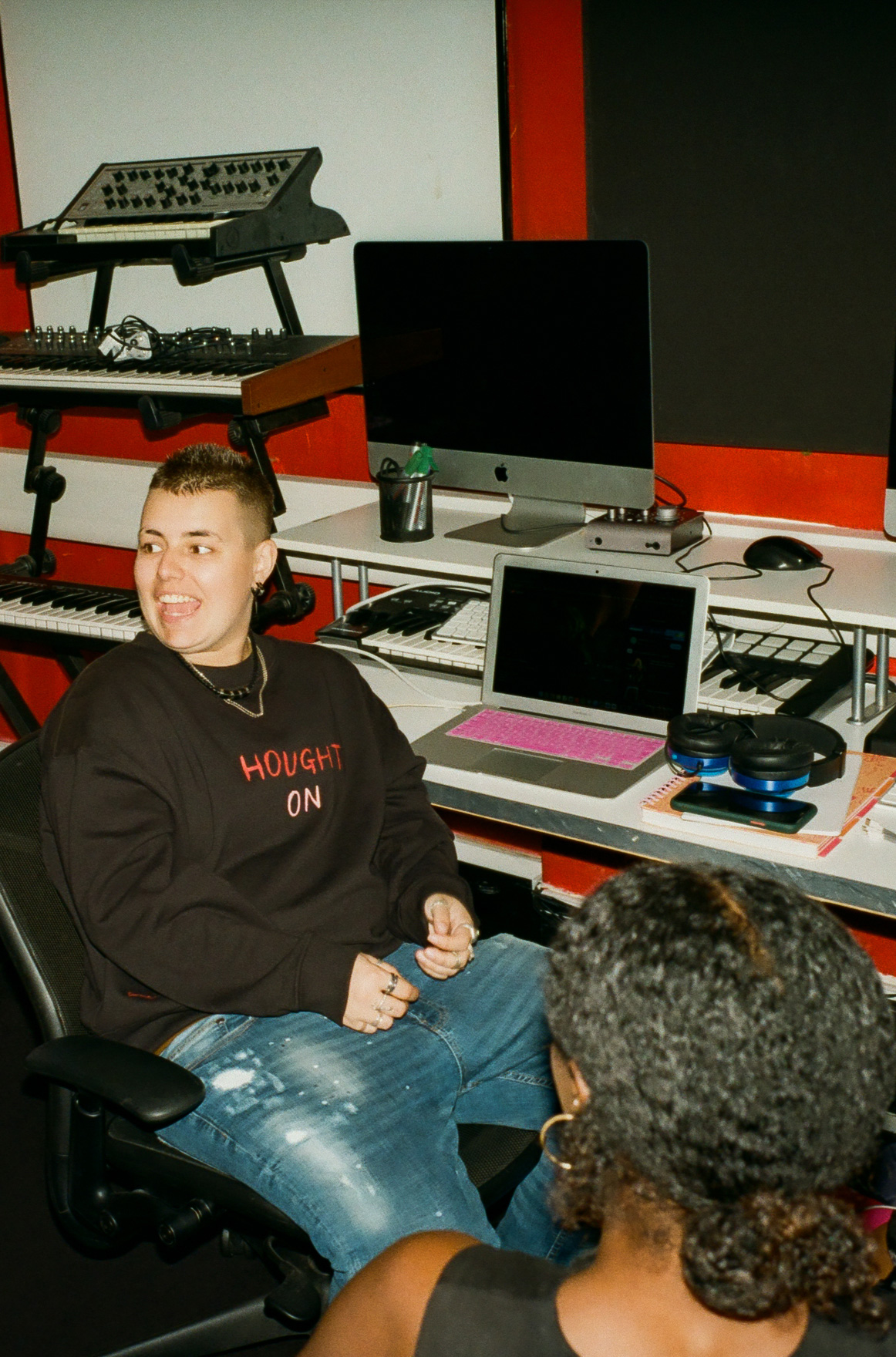 Two students are working in the music production studio, mid way through an animated conversation.